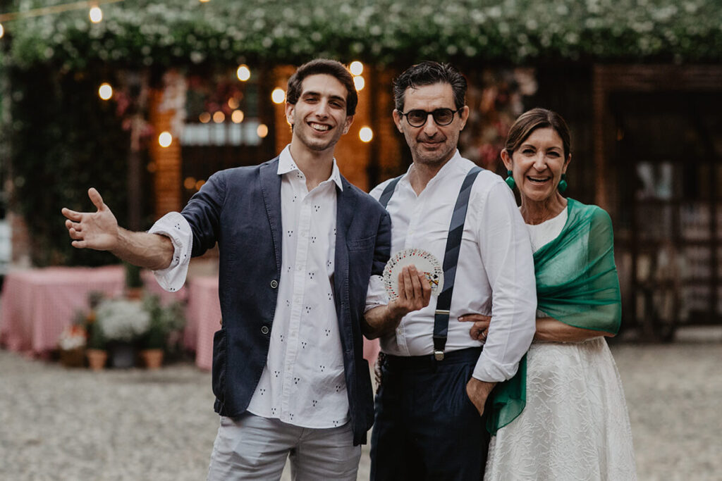 Il mago illusionista Mino e gli sposi sorridendo durante il suo servizio di magia per matrimoni.